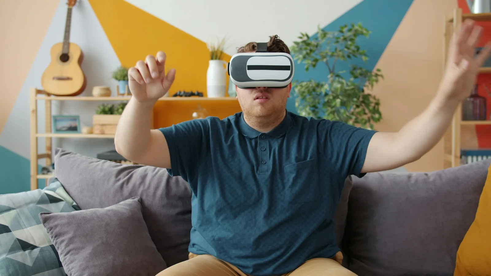 Un joven sentado en un sofá con unas gafas de realidad virtual puestas